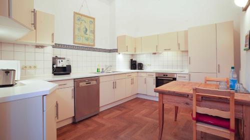 uma cozinha com armários brancos e uma mesa de madeira em FerienGut Dalwitz Gutshaus em Walkendorf
