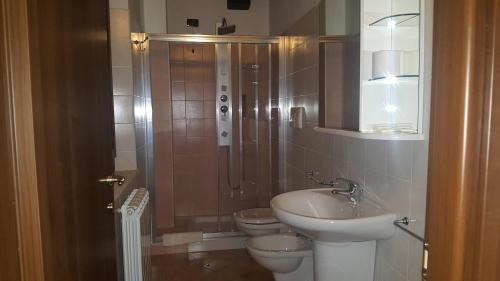 łazienka z 2 toaletami, prysznicem i umywalką w obiekcie L'Antico Casale w mieście Perugia