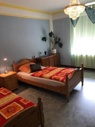 a bedroom with two beds and a chandelier at Wagner Ferien Apartments in Essen