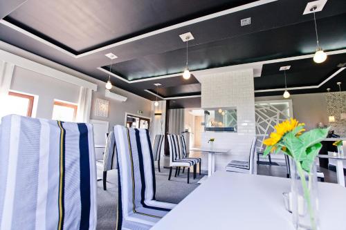 a dining room with a white table and chairs at Hotel Sulbin in Garwolin