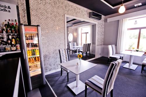 a restaurant with a table and chairs and a refrigerator at Hotel Sulbin in Garwolin