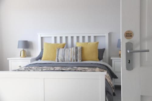 a bedroom with a bed with yellow pillows at Firbank Lodge in Glenrothes