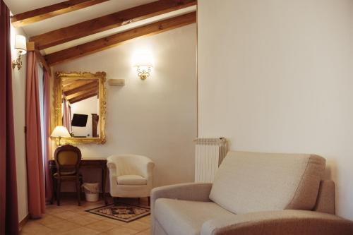 a living room with a couch and a mirror at Albergo Al Viale in Trieste