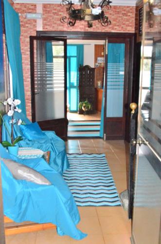 a living room with a blue bed and a rug at Residencia Santiago Mallorca in Cala Figuera