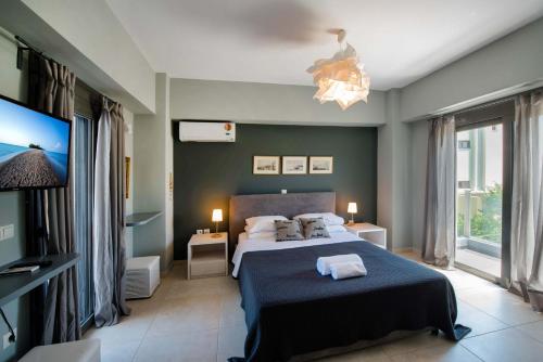a bedroom with a bed and a flat screen tv at Villa Oliva Rodos in Ialysos