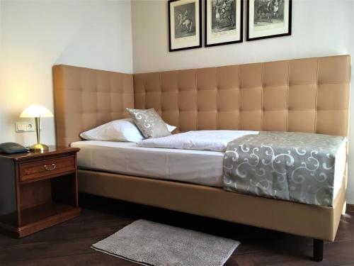 a bedroom with a large bed with a large headboard at Villa Knobelsdorff in Pasewalk