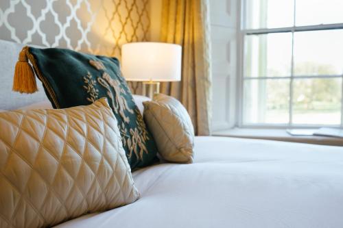 a bed with a pillow and a window at Elm Grove Country House in Tenby