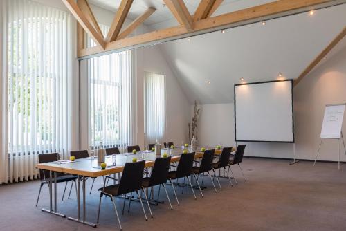 a conference room with a table and chairs and a whiteboard at Golfhotel Fahrenbach in Tröstau