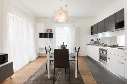 a kitchen with a table and chairs in a room at Maraini Apartments by Quokka 360 - strategic location near Lugano station in Lugano