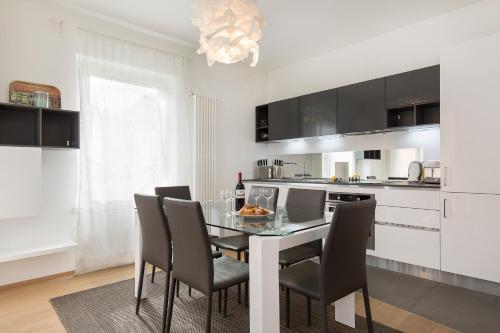 ルガノにあるMaraini Apartments by Quokka 360 - strategic location near Lugano stationのキッチン(ダイニングルームテーブル、椅子付)