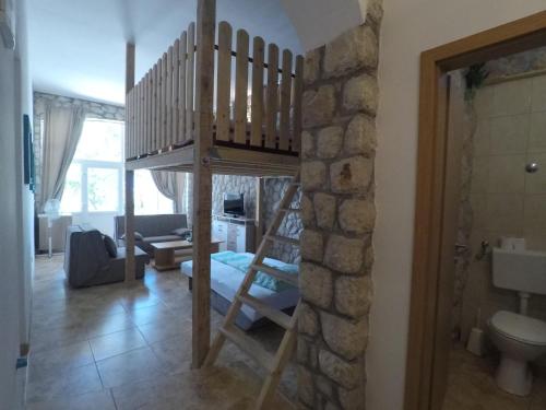a room with a loft bed and a living room at Apartments TOMMI in Dramalj