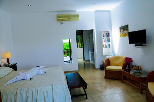 a bedroom with a bed and a living room with a tv at Waterside Bentota in Bentota