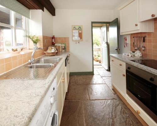 cocina con fregadero y encimera en Long Barn Holiday Cottages, en Newton Abbot