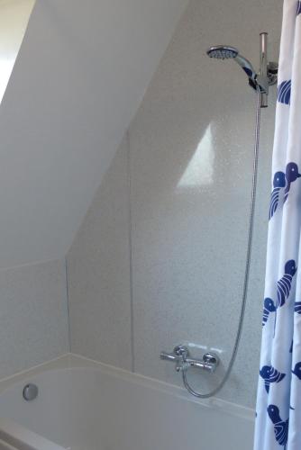 a shower in a bathroom with a shower curtain at Aultbea Lodges in Aultbea
