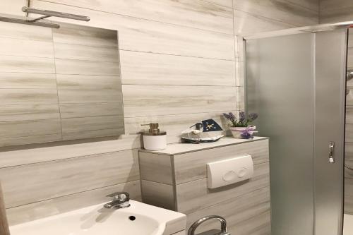 een badkamer met een wastafel en een spiegel bij Apartments Villa Stivan in Solin