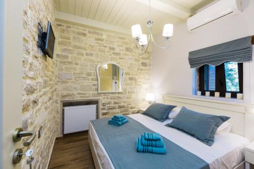 sypialnia z łóżkiem z niebieskimi poduszkami w obiekcie Caramel Villa, with 40m2 Pool & Spa Whirlpool, By ThinkVilla w mieście Panormos