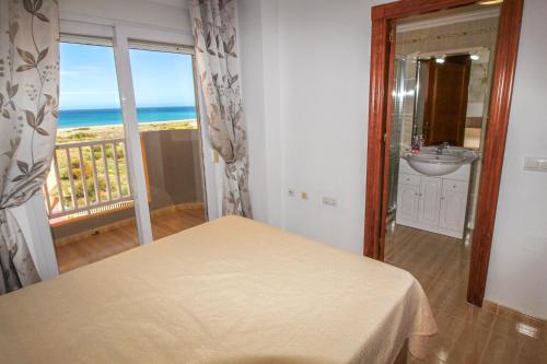 sypialnia z łóżkiem i umywalką oraz balkon w obiekcie Seychelles Two Bedroom Apartment RP043 w mieście La Manga del Mar Menor