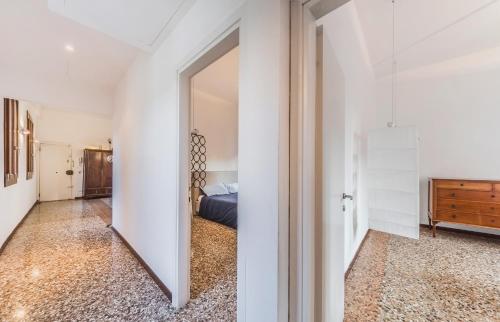 a hallway with a mirror and a bed in a room at Ca' d'Oro suite in Venice