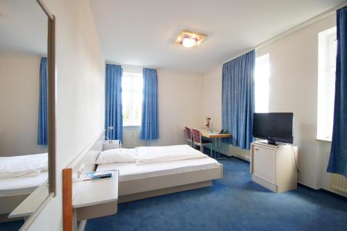 a hotel room with two beds and a television at Hotel Neuwirtshaus - Superior in Stuttgart