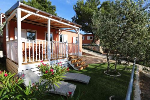 a small house with a porch and a deck at Mobile homes-Slanica in Murter