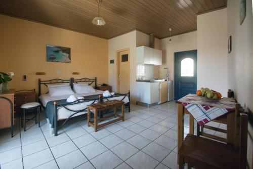 Zimmer mit einem Bett und einer Küche mit einem Tisch in der Unterkunft Belvedere Studios in Kýthira