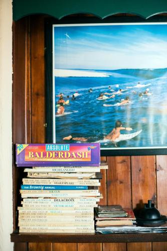 a stack of books on a shelf with a picture at Maddens Bridge Bar & Guesthouse in Bundoran