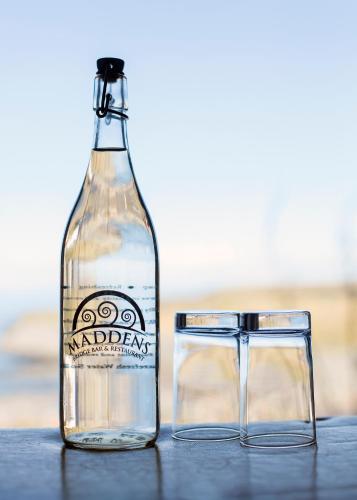 an empty bottle and a glass on a table at Maddens Bridge Bar & Guesthouse in Bundoran