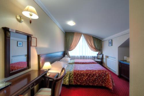 a hotel room with two beds and a large window at Dworek Hetmanski in Stargard