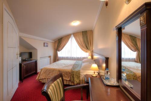 a hotel room with a bed and a mirror at Dworek Hetmanski in Stargard