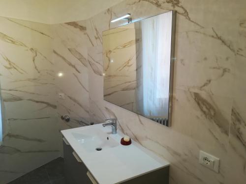 een witte badkamer met een wastafel en een spiegel bij Residenza Ca Trinità in Venetië