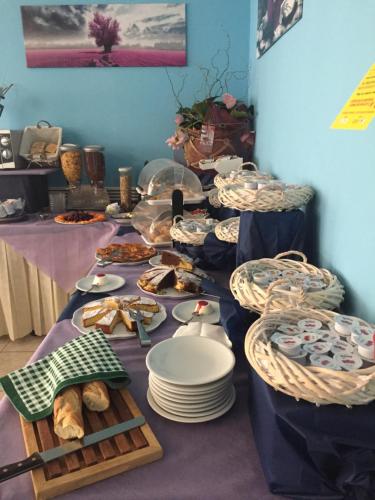 długi stół z talerzami i jedzeniem w obiekcie Hotel Adria Mare w Rimini