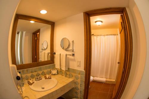 a bathroom with a sink and a mirror at Amatique Bay Hotel in Puerto Barrios