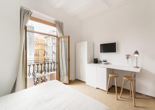 1 dormitorio con cama, escritorio y ventana en Victoria Site-Mercat Central, en Valencia