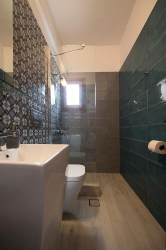 a bathroom with a toilet and a sink and a shower at Amphitrite in Myrties