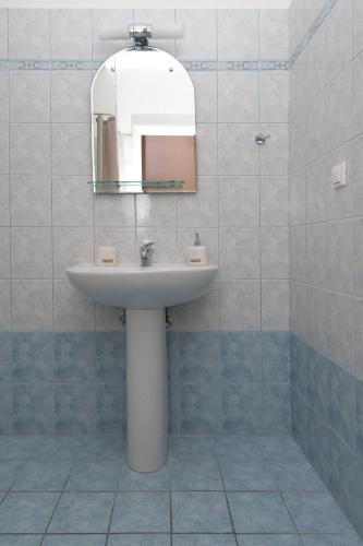 a bathroom with a sink and a mirror at Cosy 3bedroom Apartment in Sami