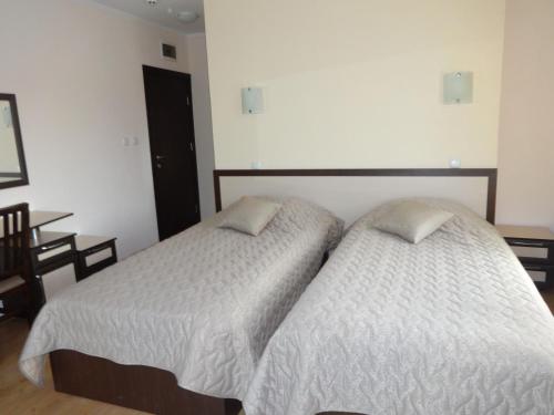 two beds sitting next to each other in a bedroom at Семеен хотел "Елеганс" - Борино in Borino