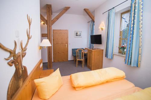1 dormitorio con 1 cama y escritorio con TV en Gutshof Colmberg, en Colmberg