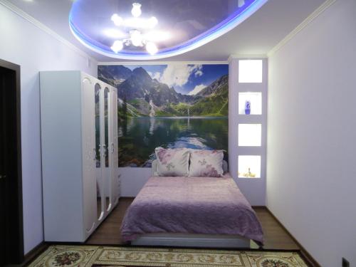 ジュコーフスキーにあるApart-Hotel on Solnechniy 10の湖と山の絵画が描かれたベッドルーム