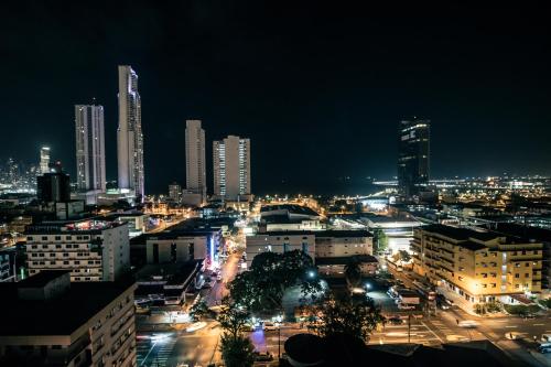 a city lit up at night with tall buildings at Hotel Faranda Express Soloy & Casino in Panama City
