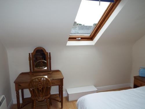 a bedroom with a desk and a bed and a window at The Stables Holiday Cottage No 9 in Woodstown