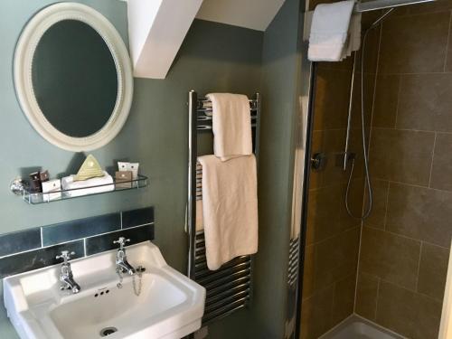 a bathroom with a sink and a mirror and a shower at The Sheep on Sheep Street Hotel in Stow on the Wold