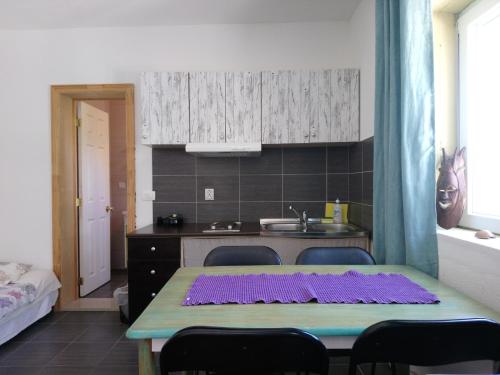 a kitchen with a table and chairs and a kitchen with a sink at Apartments Lozina in Živogošće