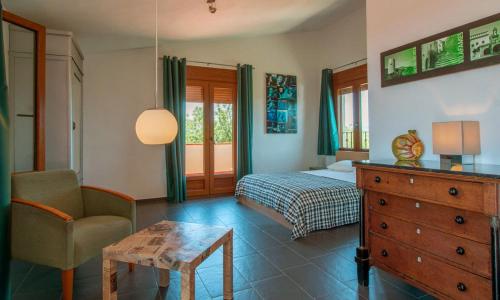 een slaapkamer met een bed, een stoel en een dressoir bij B&B Casa Rural Mas del Rey in Cálig