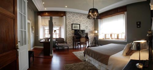 a bedroom with a bed and a desk and a window at Casón de la Marquesa in Las Fraguas