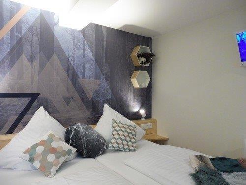 a bedroom with a bed with pillows on it at Hostellerie Les Bagenelles in Sainte-Marie-aux-Mines