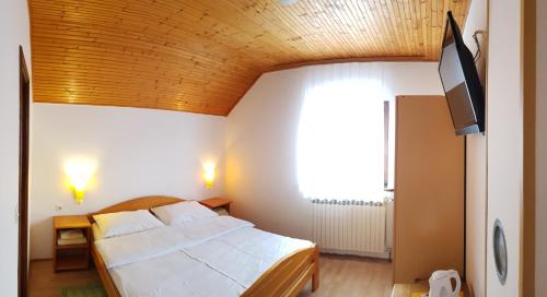 a bedroom with a large bed with a wooden ceiling at House Anamarija in Seliste Dreznicko