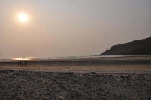 a group of people standing on a beach at Hotel Grand Ganesha in Ganpatipule