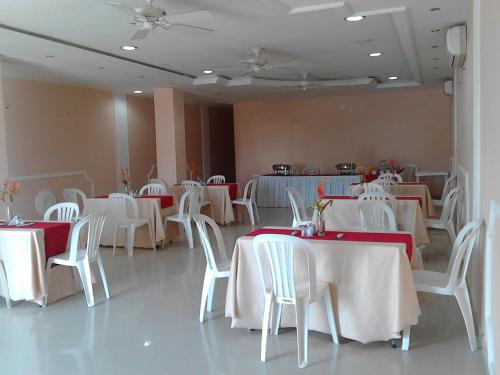 jadalnia z białymi stołami i białymi krzesłami w obiekcie Hotel Dainner w mieście Plato