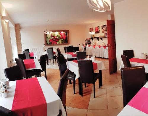 a restaurant with red and white tables and chairs at Willa Adonis in Świnoujście