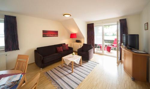a living room with a couch and a tv at Ferienhaus Kur & Golf in Bad Windsheim